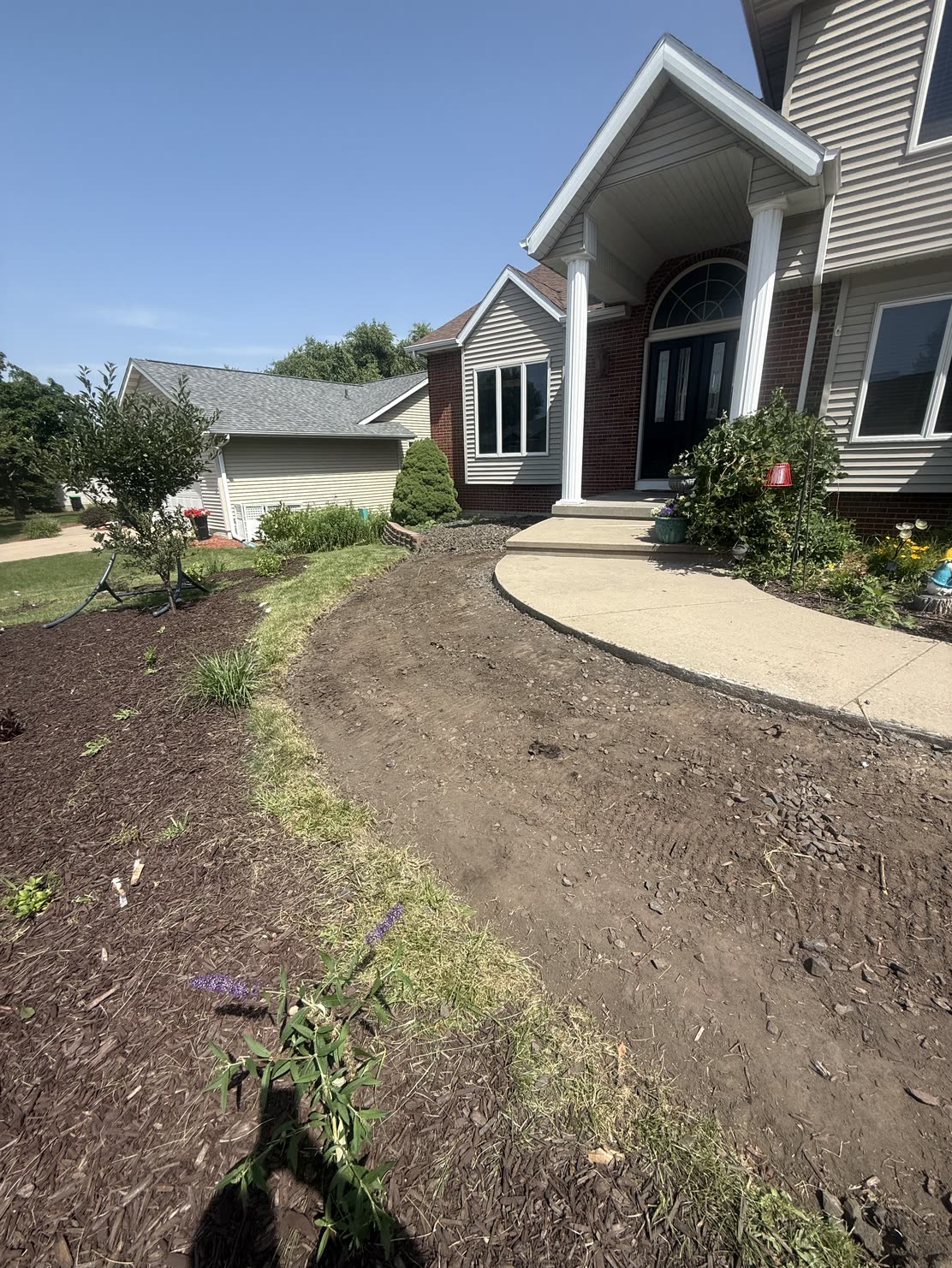 The same front with the old plantings pulled out and the bed cut back to clean soil