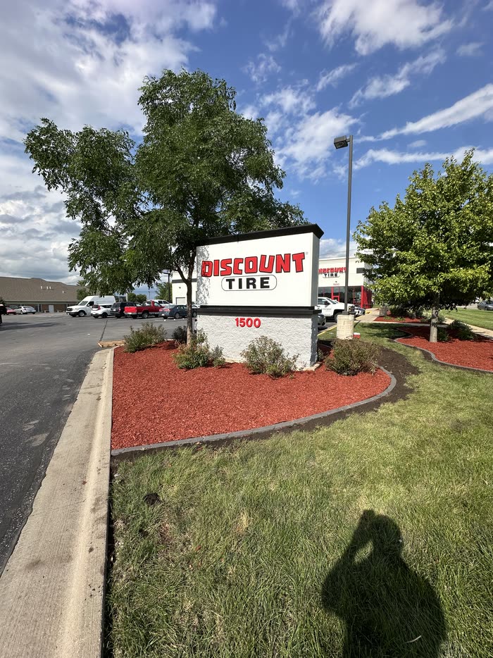 Red mulch bed and shrubs built around a commercial sign