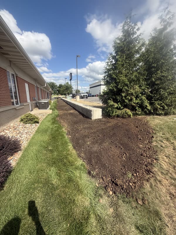 Long soil bed prepared along a brick building